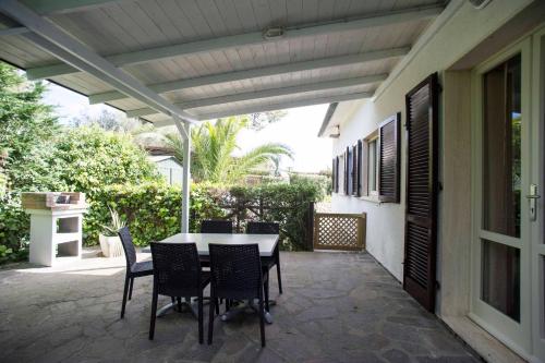 a patio with a table and chairs under awning at Il Caubbio in Lacona
