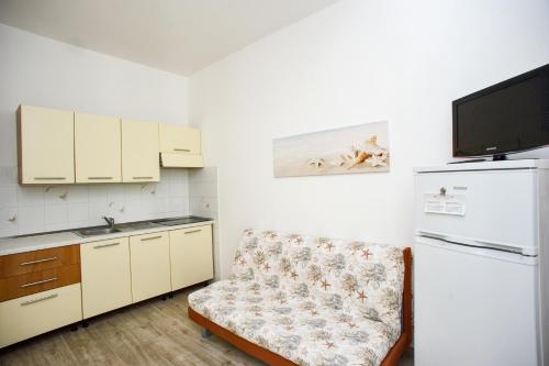 a small kitchen with a couch and a refrigerator at Il Caubbio in Lacona