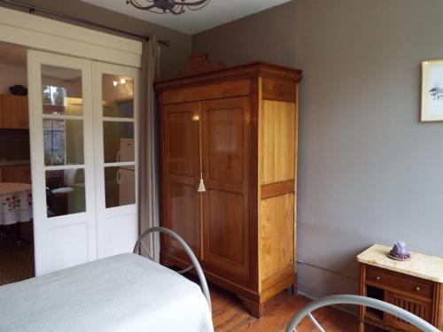 a bedroom with a wooden cabinet and a bed at La Maison d'Antoine in Maison-Ponthieu