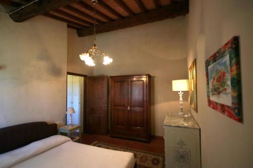 a bedroom with a bed and a chandelier at La Casa delle Rose in Terranuova Bracciolini