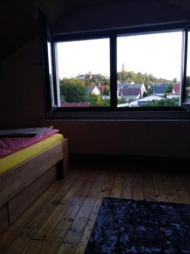 Habitación con cama y ventana grande. en Ferienhaus Ullrich en Augustusburg