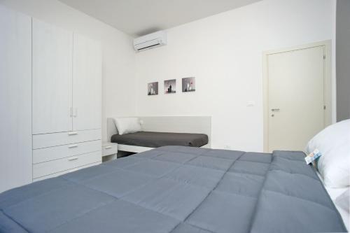 a white bedroom with a bed and a chair at Il Caubbio in Lacona