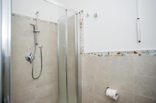 a shower with a glass door in a bathroom at Il Caubbio in Lacona