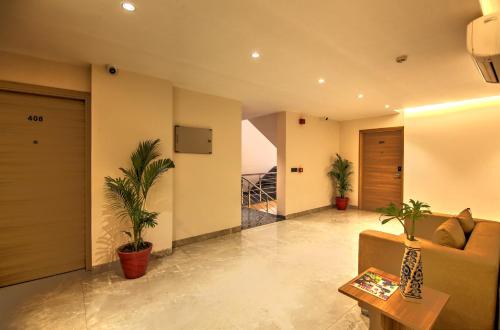 a living room with a couch and potted plants at Hotel 91 Huda City Centre in Gurgaon