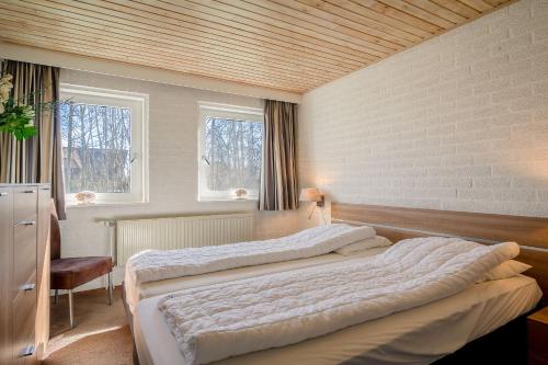 two beds in a room with two windows at Hoogelandt 92 in De Koog