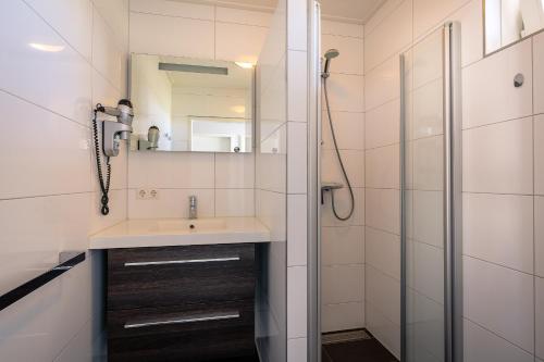 a bathroom with a sink and a shower at Hoogelandt 92 in De Koog