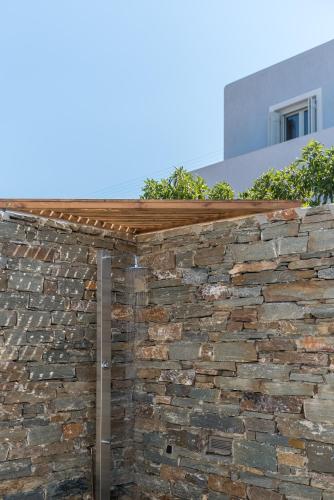 a brick retaining wall with a wooden roof at Nevermind vacations villaB in Kastrianí