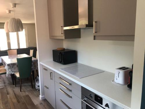 une cuisine avec un comptoir et une table avec un micro-ondes dans l'établissement Villa Marie, à Lacanau