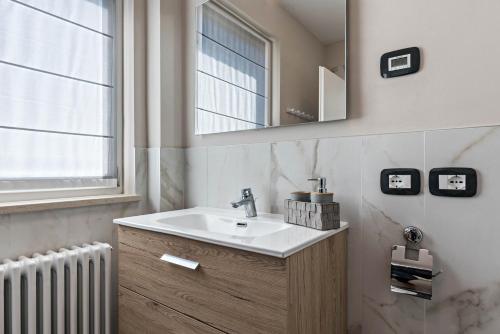 La salle de bains est pourvue d'un lavabo, d'un miroir et d'un radiateur. dans l'établissement Villa Vacanze Renetta, à Tuenno