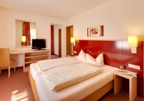 Habitación de hotel con cama grande y escritorio. en Hotel Gerloserhof GMBH, en Gerlos