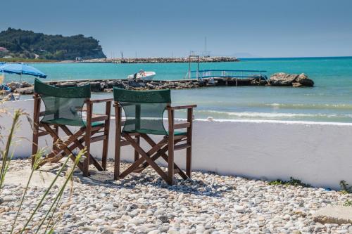 two chairs and a table on a beach at Angela Beach Hotel & Apts in Roda