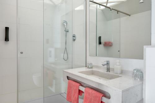 a bathroom with a sink and a shower with red towels at Hotel Continental Palacete in Barcelona