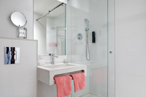 a white bathroom with a sink and a shower at Hotel Continental Palacete in Barcelona