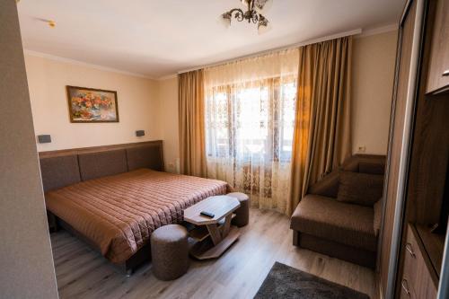 a bedroom with a bed and a couch and a window at Готель-ресторан Каміла in Polyana