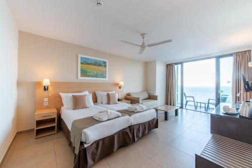 a bedroom with a large bed with a view of the ocean at The Preluna Hotel in Sliema