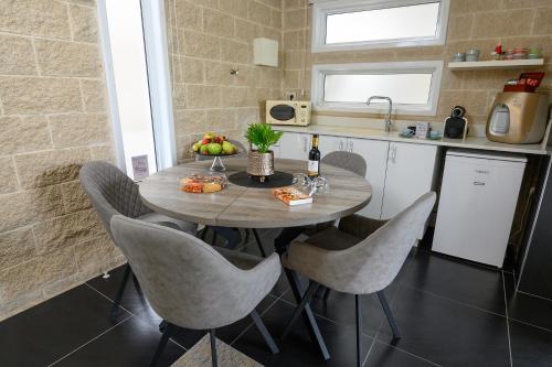 a kitchen with a table with chairs and a sink at אחוזת מיא - סוויטות בוטיק על המים in Goren