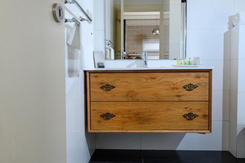 een badkamer met een wastafel en een spiegel bij אחוזת מיא - סוויטות בוטיק על המים in Goren