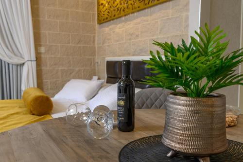 a bottle of wine sitting on a table with a plant at אחוזת מיא - סוויטות בוטיק על המים in Goren