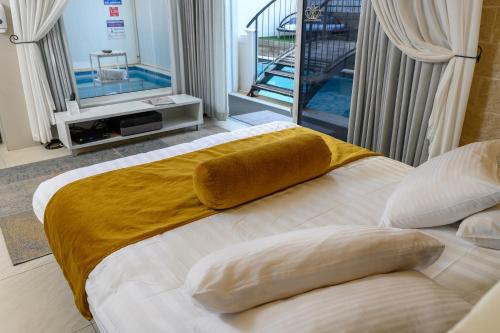 a bedroom with a large bed with a yellow blanket on it at אחוזת מיא - סוויטות בוטיק על המים in Goren