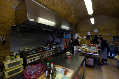 a kitchen with two people preparing food in a kitchen at Masseria Sant'Agapito in Lucera
