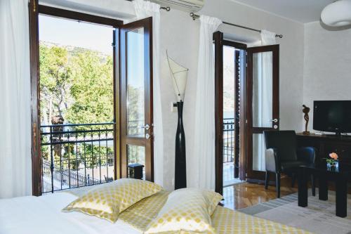 a bedroom with a bed and a view of a balcony at Villa Franica in Dubrovnik