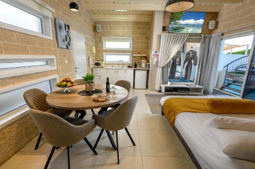 a kitchen and dining room with a table and chairs at אחוזת מיא - סוויטות בוטיק על המים in Goren