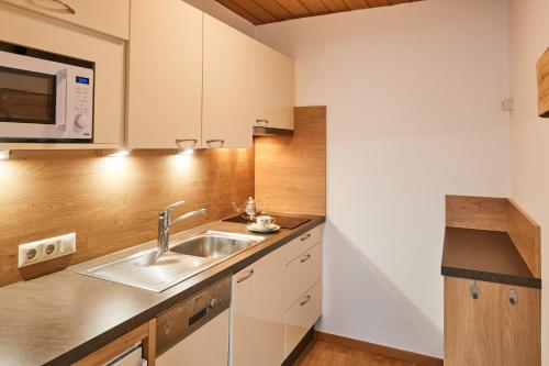 a kitchen with a sink and a microwave at Appartements Sailer in Prutz