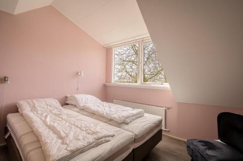 a bed in a room with a window at Nieuwlanderweg 65 in De Waal