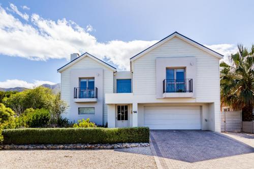 a white house with a garage at Nerf-af Cottage and private ROOMs at Onrus , Hermanus in Hermanus