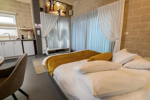 a bedroom with a large bed with pillows on it at אחוזת מיא - סוויטות בוטיק על המים in Goren