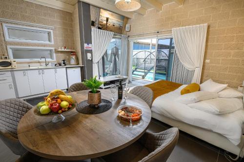 a kitchen and a table with a bowl of fruit on it at אחוזת מיא - סוויטות בוטיק על המים in Goren