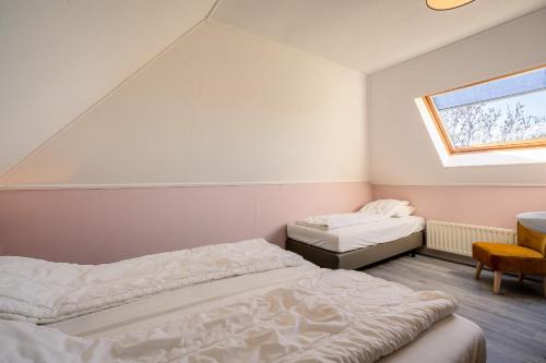 1 dormitorio con 2 camas y ventana en Nieuwlanderweg 69, en De Waal