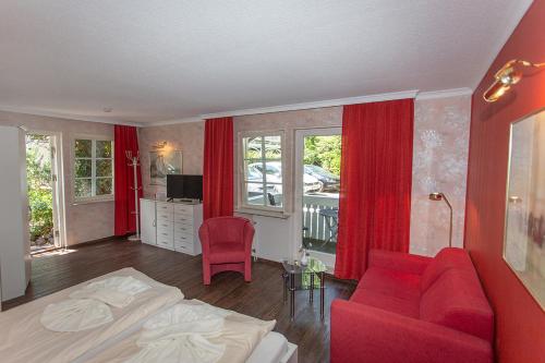 a living room filled with furniture and a red couch at Hotel Im Schwedischen Hof in Binz