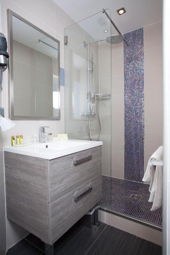 a bathroom with a sink and a shower at Hôtel Baptistin in Le Lavandou