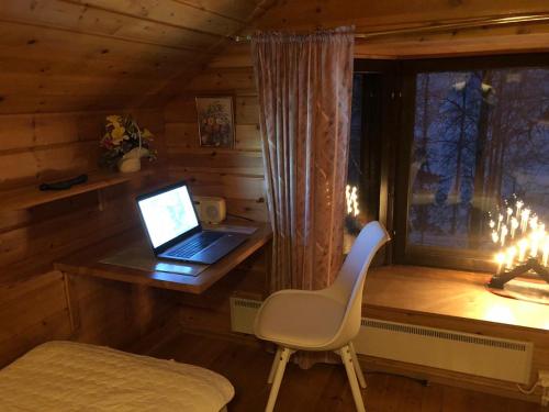 un ordenador portátil sentado en un escritorio en una cabina en Aarnitupa, cottage by lake Kylmäluoma, 