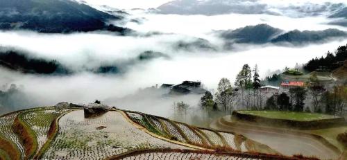 a view of a mountain with clouds in the valley at Longji Terrace La vie Inn in Longsheng