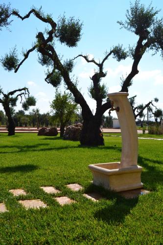 a stone planter in a park with a tree at Villa D'Anzi B&B in Ginosa