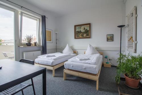 um quarto de hotel com duas camas e uma mesa em ROOM 1 / ROOM 2 em Karlsruhe