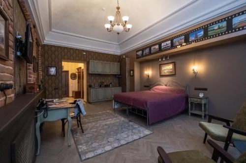 um quarto com uma cama rosa e uma mesa em Отель-музей Казанский em Kazan