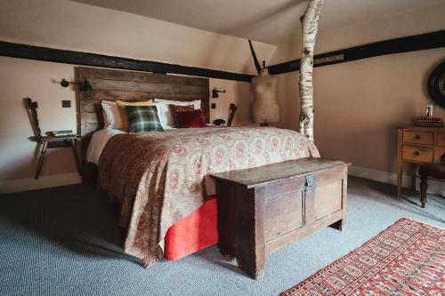 a bedroom with a large bed and a wooden table at The Bell in Ticehurst in Ticehurst