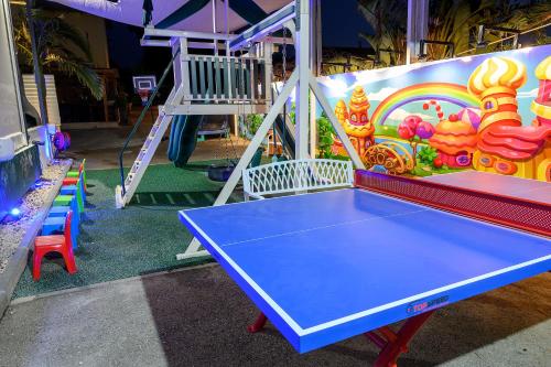 a blue ping pong table in front of a playground at אחוזת מיא - סוויטות בוטיק על המים in Goren