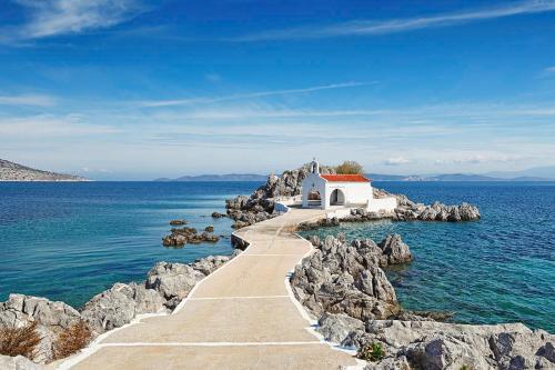 a small chapel on a rocky island in the water at Filoxenia Hotel in Chios