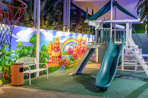 a playground with a slide in front of a mural at אחוזת מיא - סוויטות בוטיק על המים in Goren