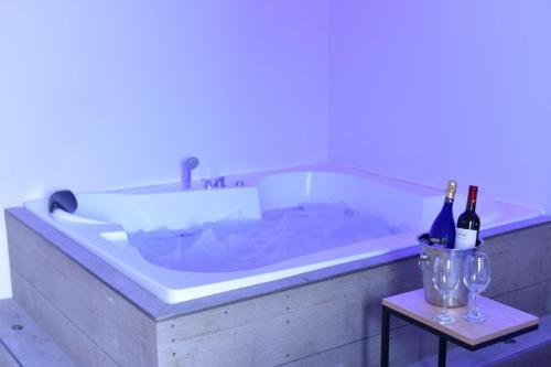 a bath tub with a sink and two bottles of wine at Private pool Luxury penthouses sea view Eilat in Eilat