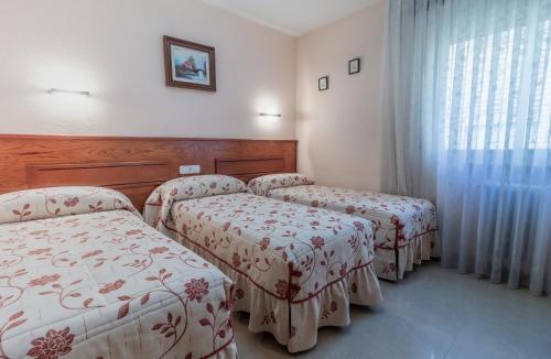 Habitación con 2 camas y ventana en Pensión Isabel by Vivere Stays, en Salamanca