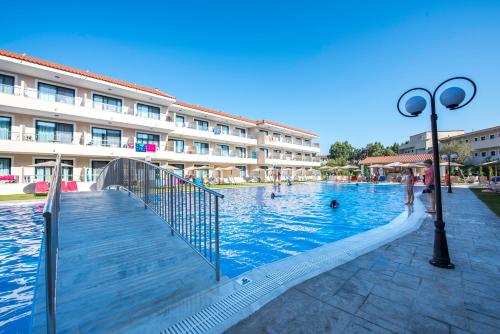 a swimming pool in front of a building at Angela Beach Hotel & Apts in Roda