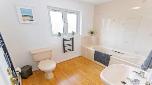 a bathroom with a toilet and a sink and a tub at Oceanside Croyde, Scandi inspired cottage close to Croyde Beach - Sleeps 6 in Croyde