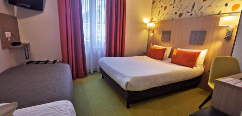 a hotel room with two beds with orange pillows at Hotel Continental in Angers