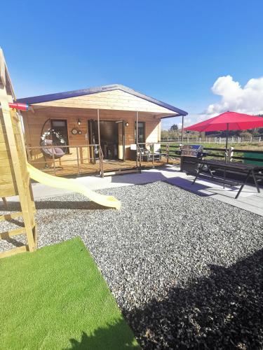 a building with a playground with a yellow slide at The Lodge Mountain View Log Cabin , Attymass Ballina in Boyhollagh