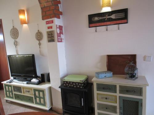 a living room with a tv and a dresser at Casa O Cantinho Algarvio in Odeceixe
